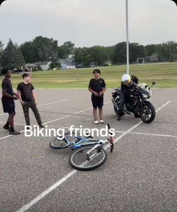 Isra Yasin outside with friends, bikes and a motorcycle, in the biking friends sketch
