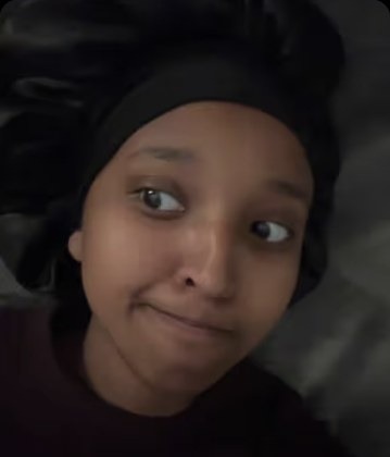 Isra Yasin laughing in a cream sweater during the "THE HOUSE" bit